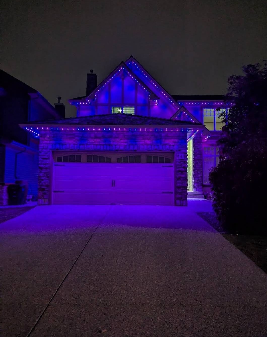 Winnipeg home with blue and purple outdoor LED lighting and garage